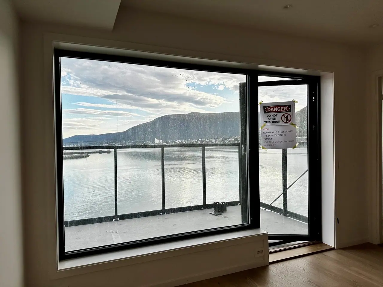 Open-plan living room/kitchen with large windows that let in plenty of light and give views across the sound.