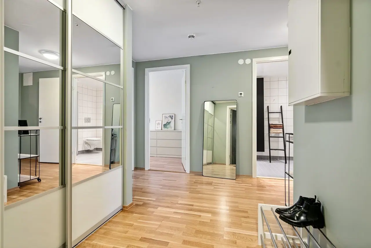 Spacious hallway with mirrored cabinet.
